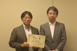 賞状を手にした八幡憲明研究員