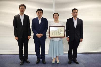 表彰状を持つ女性とスーツの男性