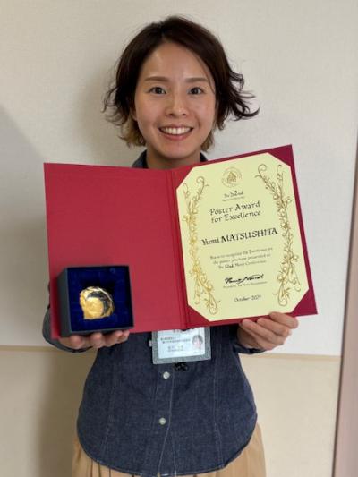 表彰状を手にもつ女性