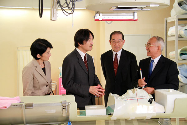 治療室で重粒子線がん治療の照射方法について説明を受けられる秋篠宮両殿下