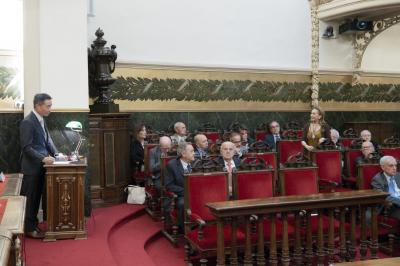 A man in a suit standing at the podium.