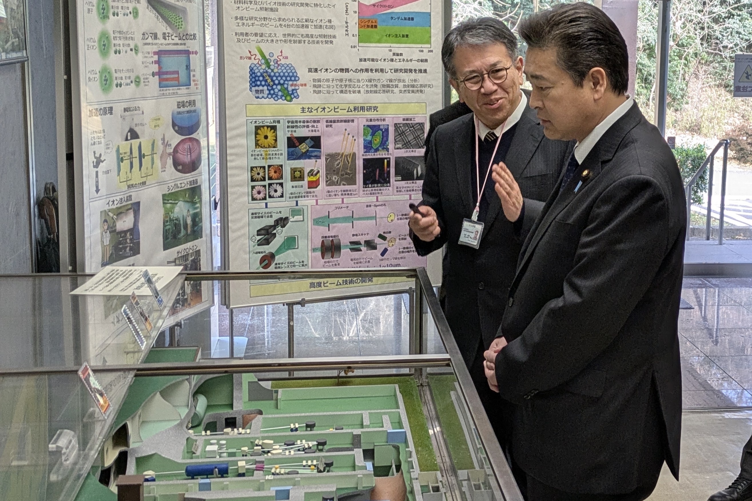 先進ビーム利用施設部・杉本部長からTIARAの全体図について説明を受けている様子