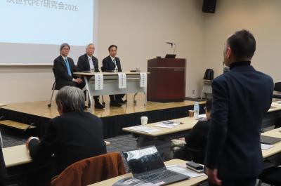 演題に並ぶスーツを着た3人の男性