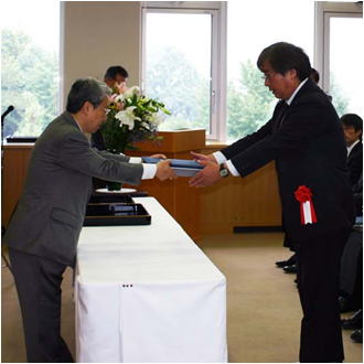 近藤国立科学博物館館長から登録証と記念盾を授与される岡田理事（右）の画像