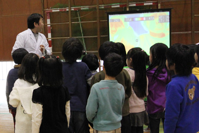 温度がわかるカメラの前で姿を映す子どもたちの画像