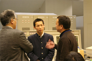 中国科学院プラズマ物理研究所（安徽省、合肥市）から実験参加しているZhao教授に質問する高校生。の画像